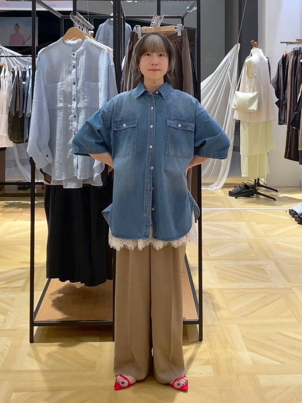 レッド系のサンダル、ブルー系のシャツ/ブラウス、ベージュ系のスラックスを着用したレディースの春コーディネートの6枚目の写真