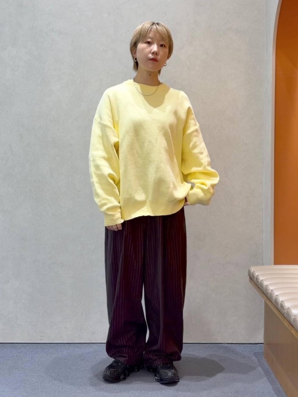 ブラウン系のその他パンツ、イエロー系のニット/セーターを着用したレディースの春コーディネートの5枚目の写真