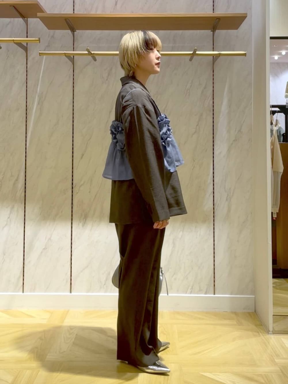 グレー系のスラックス、グレー系のテーラードジャケット、シルバー系のトートバッグを着用したレディースの春コーディネートの4枚目の写真