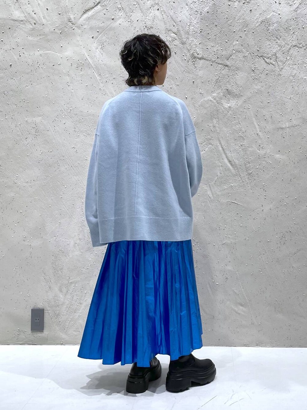 ブラック系のブーツ、ブルー系のニット/セーター、ブルー系のスカートを着用したレディースの秋コーディネートの3枚目の写真