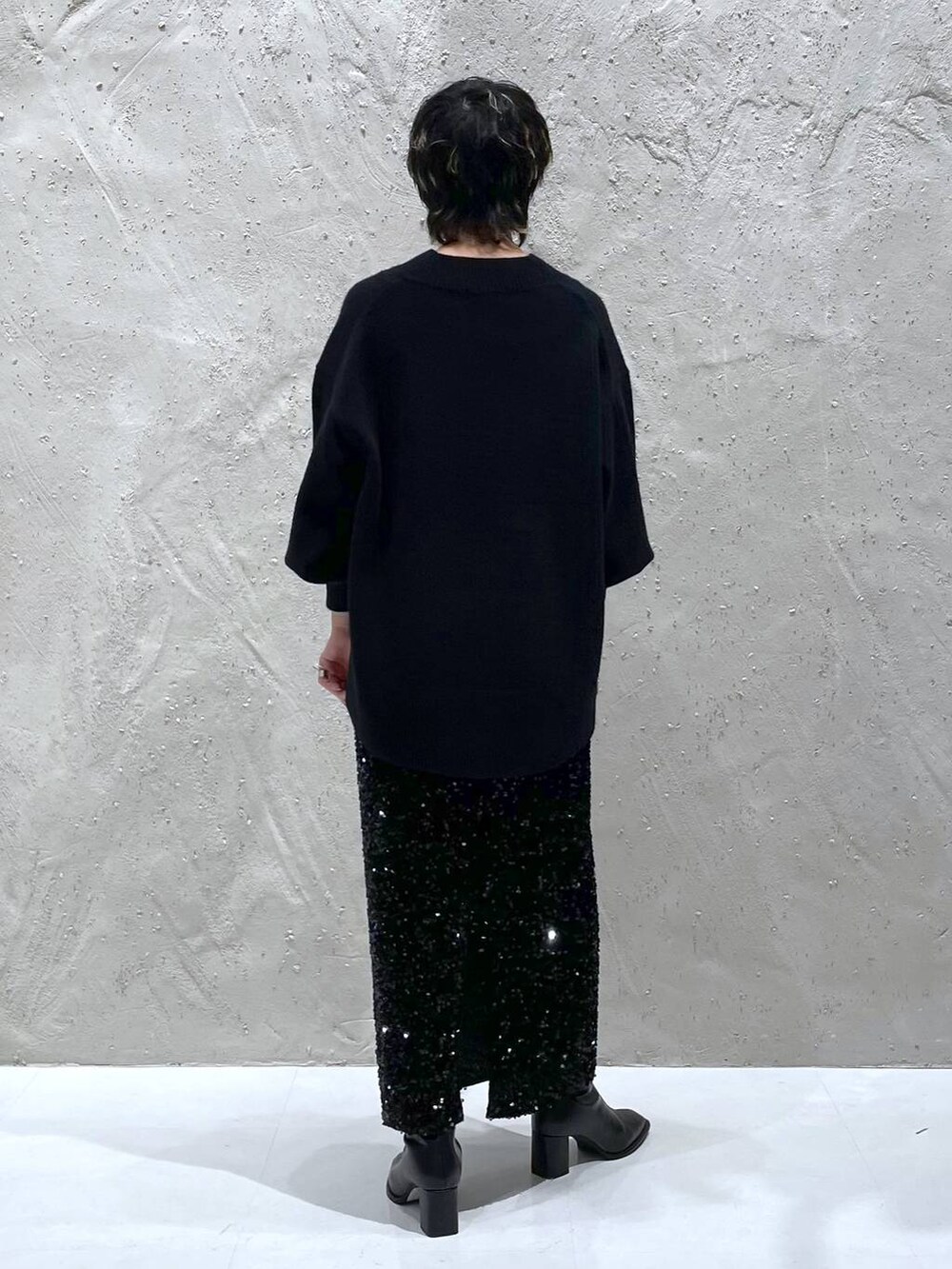 ブラック系のパンプス、ブラック系のニット/セーター、ブラック系のスカートを着用したレディースの秋コーディネートの3枚目の写真