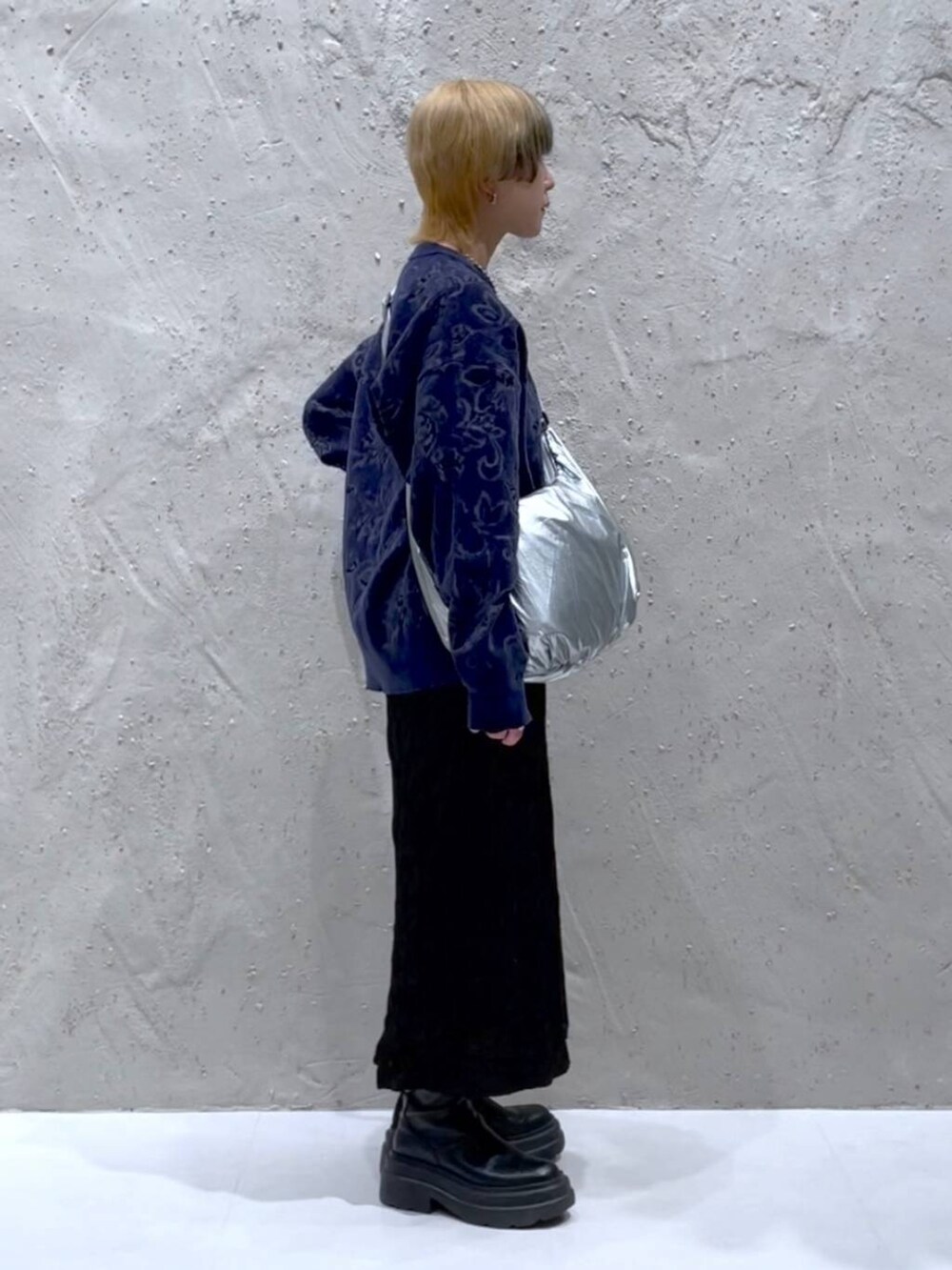 ブルー系のニット/セーター、ブラック系のスカート、シルバー系のショルダーバッグを着用したレディースの秋コーディネートの4枚目の写真