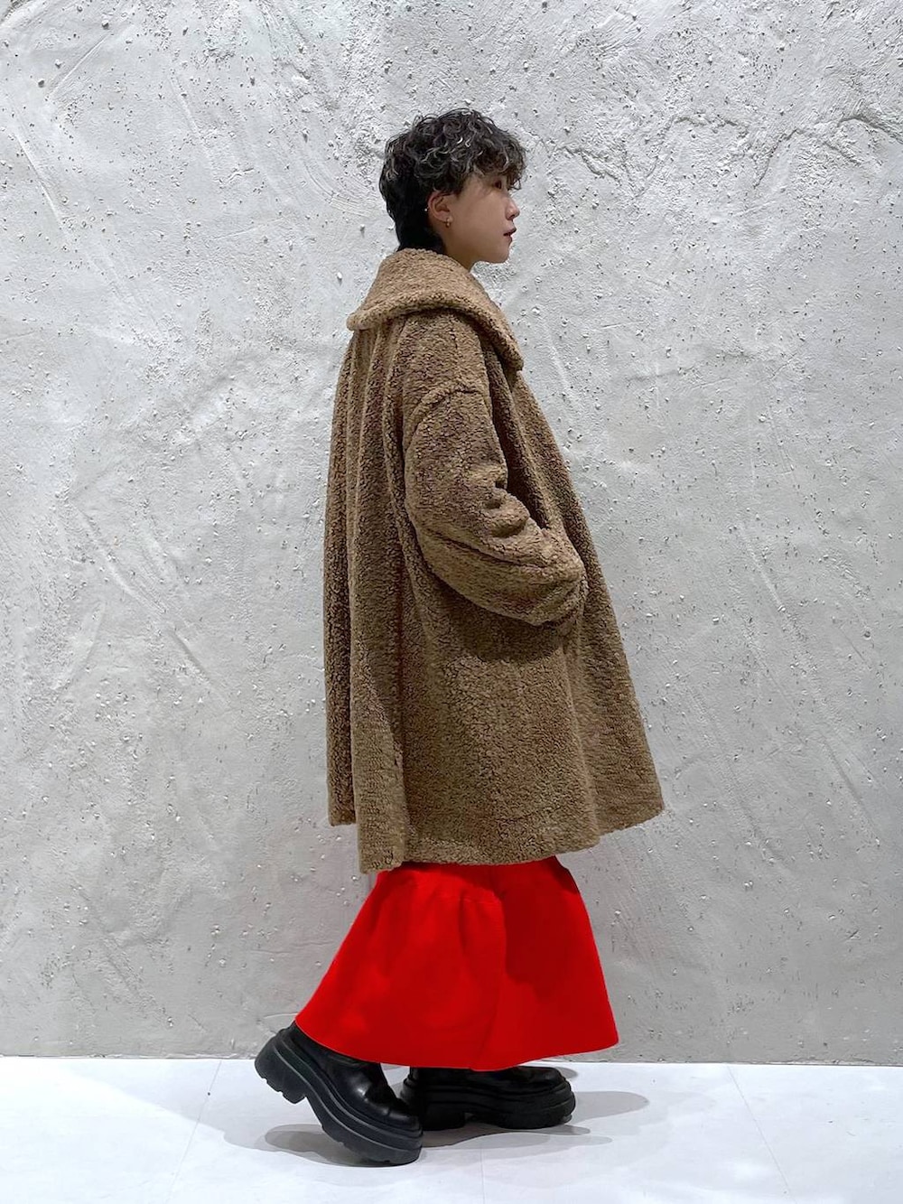 ブラック系のブーツ、ブラウン系のその他アウター、レッド系のワンピースを着用したレディースの冬コーディネートの4枚目の写真