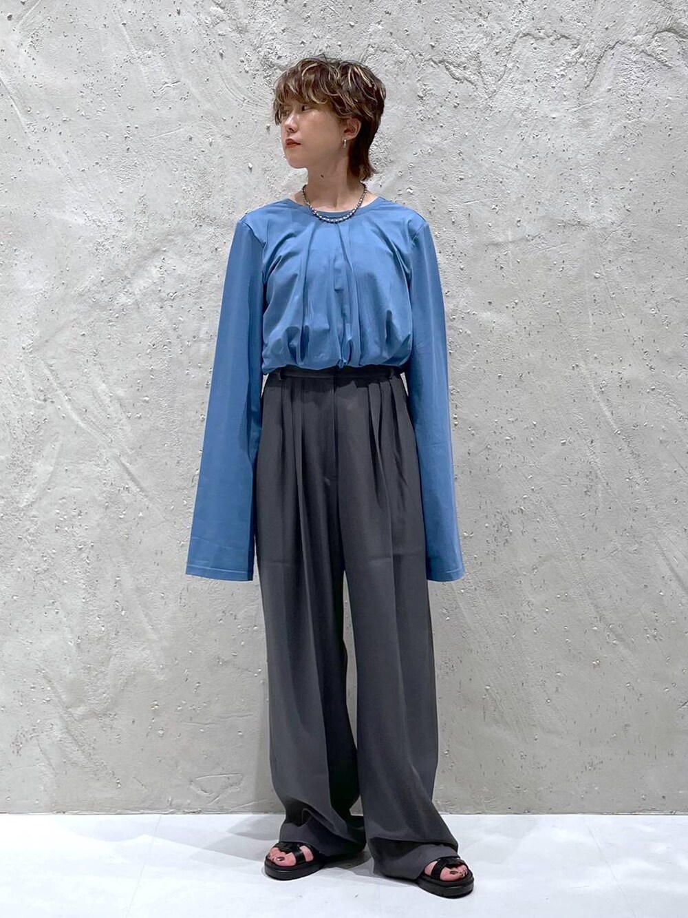 グレー系のスラックス、ブルー系のTシャツ/カットソーを着用したレディースの夏コーディネートの4枚目の写真