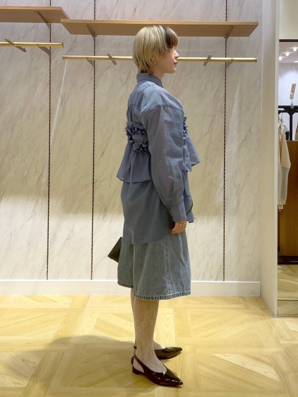 ブルー系のシャツ/ブラウス、ブルー系のキャミソール、ブラック系のショルダーバッグを着用したレディースの春コーディネートの4枚目の写真