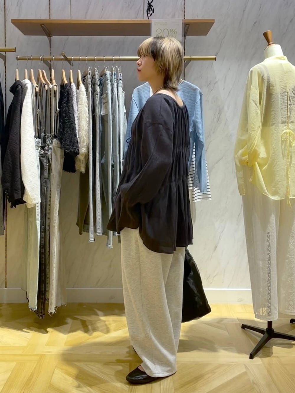 グレー系のシャツ/ブラウス、ブラック系のスニーカー、グレー系のスウェットパンツを着用したレディースの春コーディネートの2枚目の写真