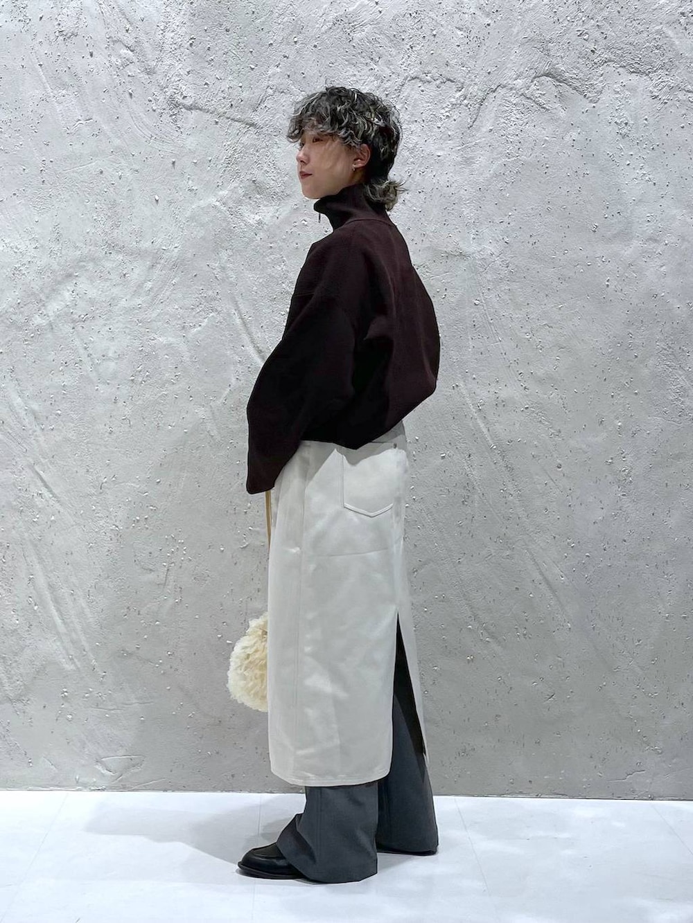 グレー系のその他パンツ、ベージュ系のスカート、ホワイト系のハンドバッグを着用したレディースの春コーディネートの6枚目の写真