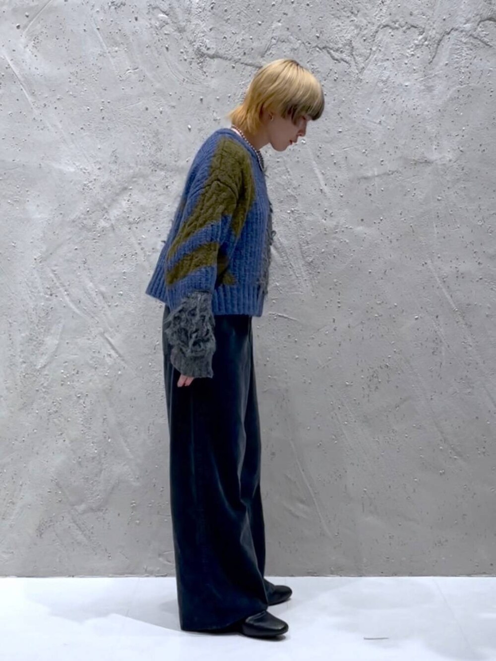 ブラック系のブーツ、ブルー系のニット/セーター、イエロー系のショルダーバッグを着用したレディースの秋コーディネートの2枚目の写真