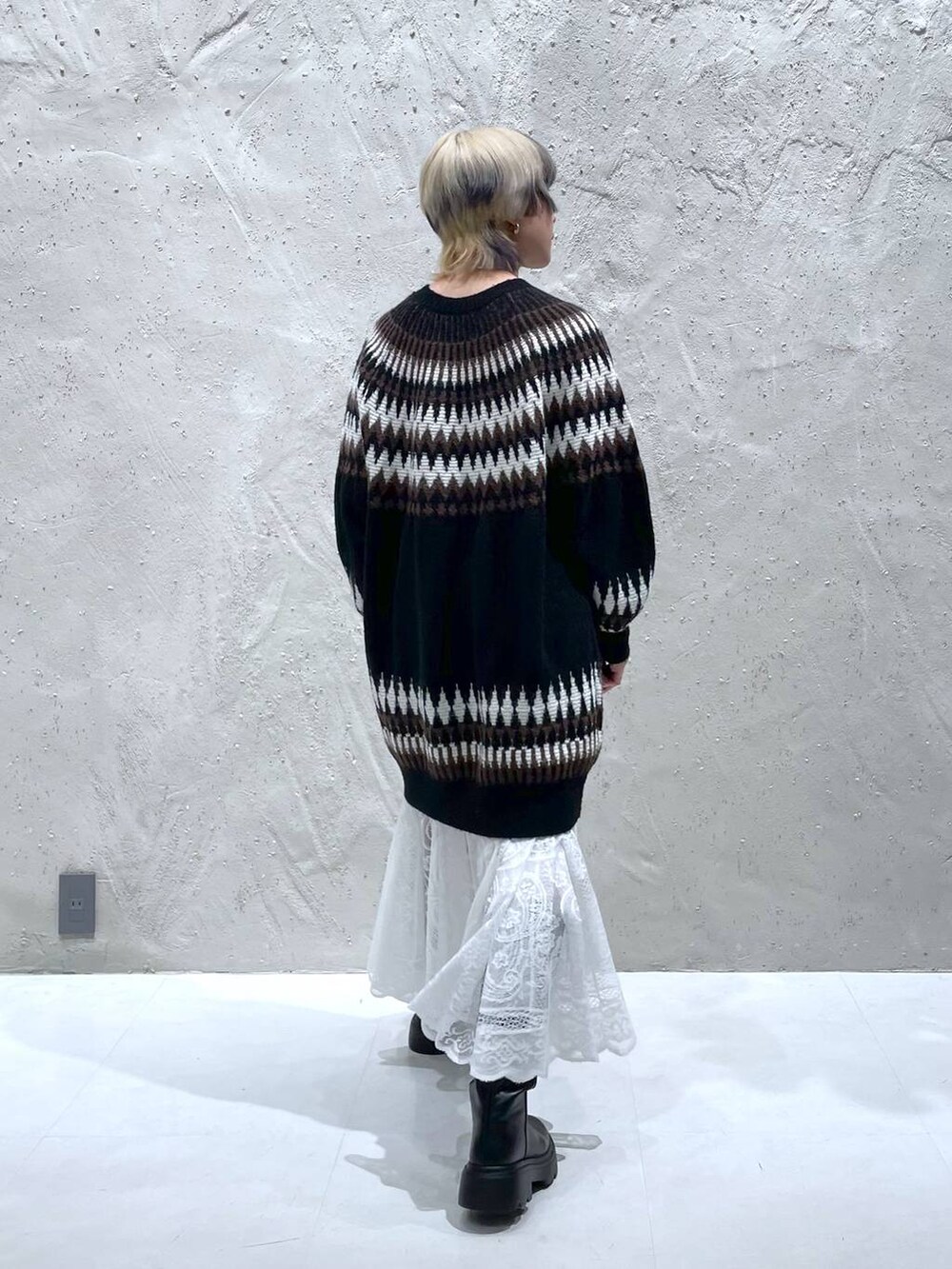 ホワイト系のスカート、ブラック系のブーツ、ブラック系のワンピースを着用したレディースの冬コーディネートの6枚目の写真