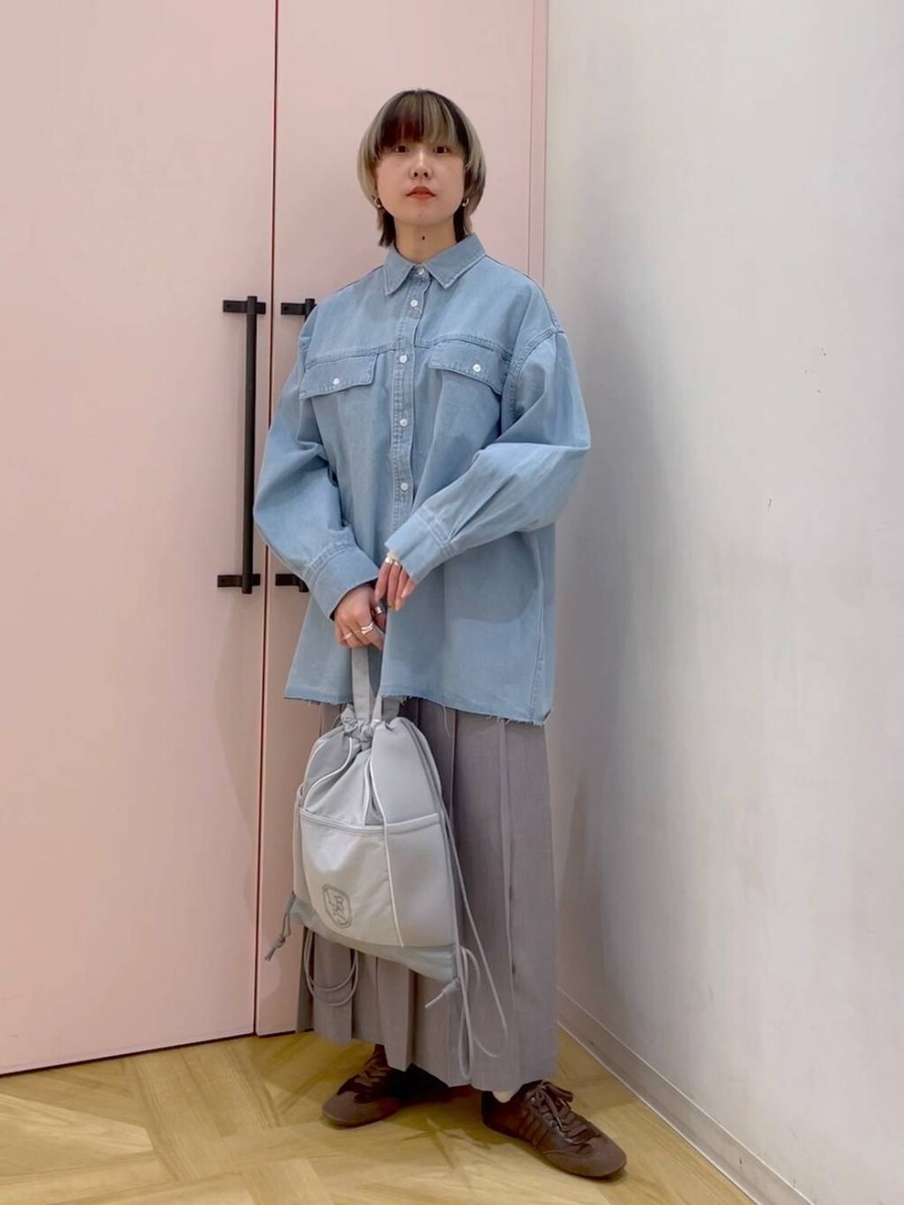 ブラウン系のスニーカー、グレー系のバックパック/リュック、ブルー系のシャツ/ブラウスを着用したレディースの冬コーディネートの5枚目の写真