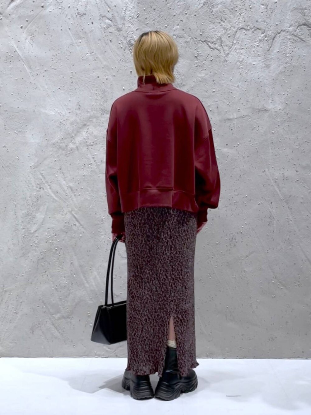 ブラック系のブーツ、ブラック系のショルダーバッグ、その他のスカートを着用したレディースの秋コーディネートの3枚目の写真