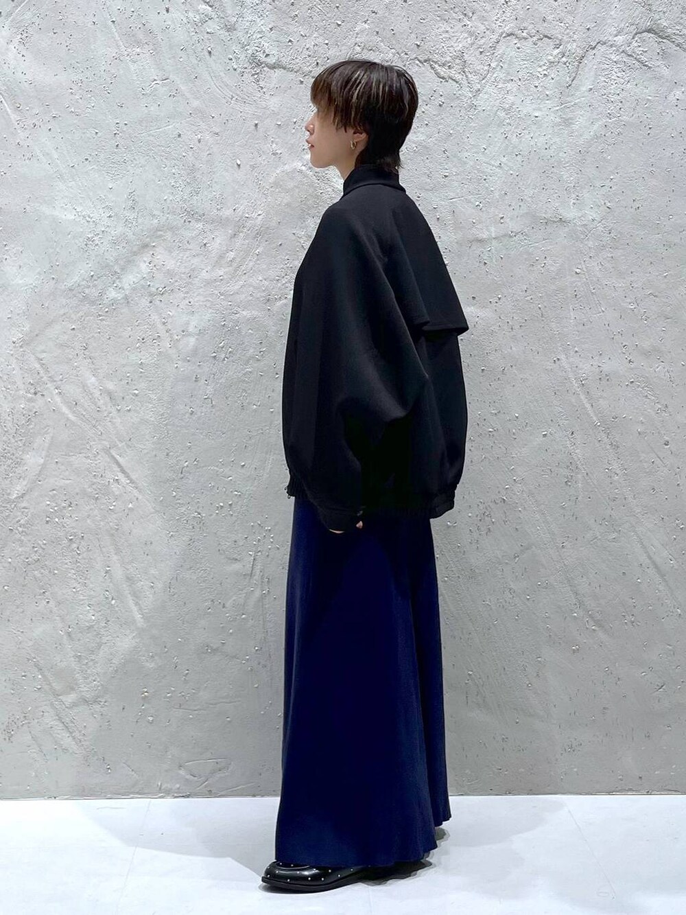 ブラック系のブルゾン、ブルー系のワンピース、ブラック系のローファーを着用したレディースの秋コーディネートの2枚目の写真