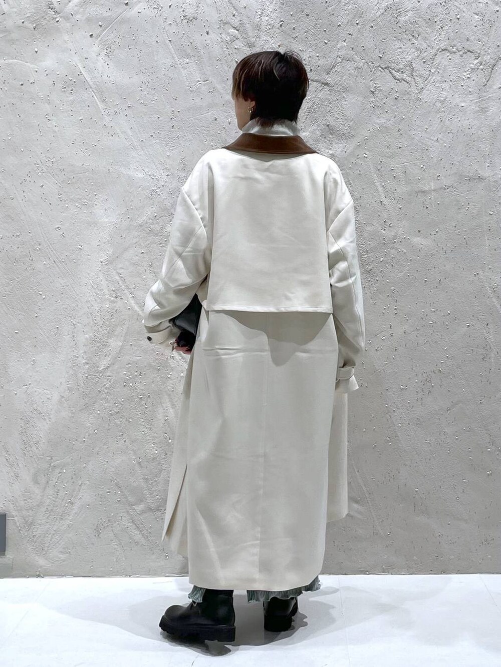 ブラック系のショルダーバッグ、ホワイト系のスウェット、ホワイト系のステンカラーコートを着用したレディースの秋コーディネートの3枚目の写真