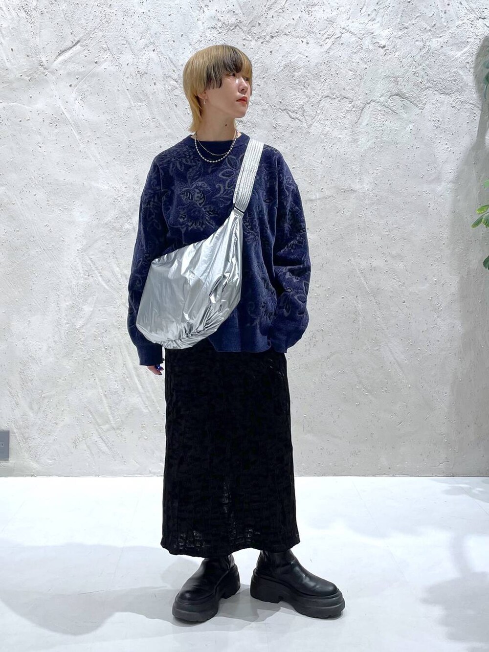 ブルー系のニット/セーター、ブラック系のスカート、シルバー系のショルダーバッグを着用したレディースの秋コーディネートの5枚目の写真