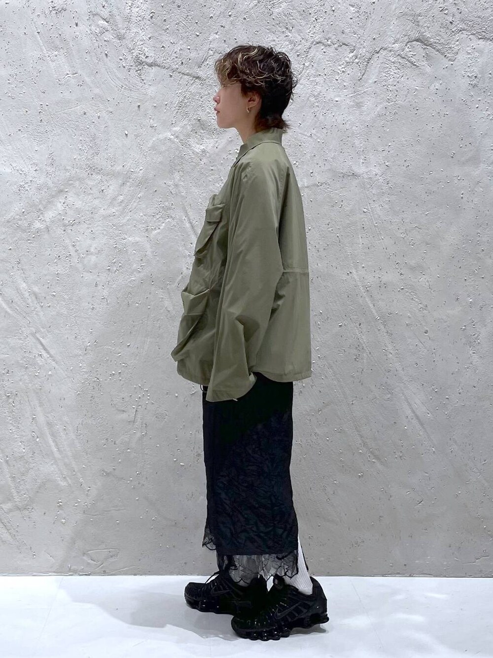 グリーン系のブルゾン、ブラック系のスカートを着用したレディースの夏コーディネートの2枚目の写真