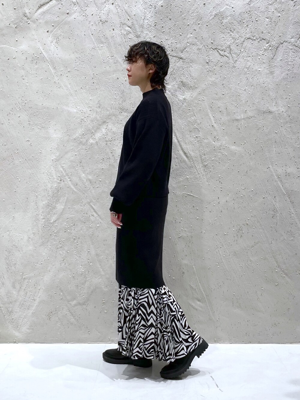 ブラック系のワンピース、ブラック系のスカート、ブラック系のブーツを着用したレディースの冬コーディネートの2枚目の写真