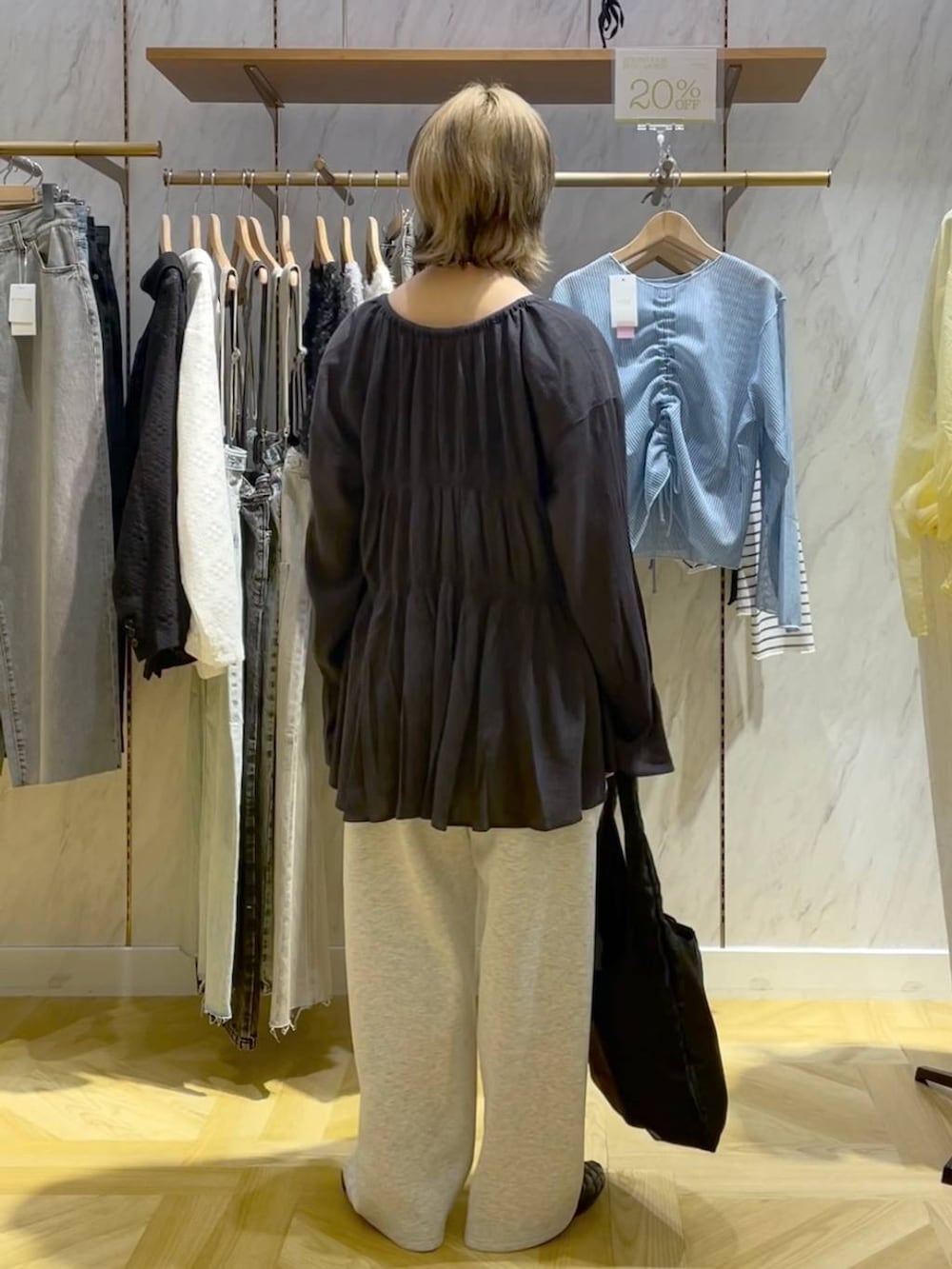 グレー系のシャツ/ブラウス、ブラック系のスニーカー、グレー系のスウェットパンツを着用したレディースの春コーディネートの3枚目の写真