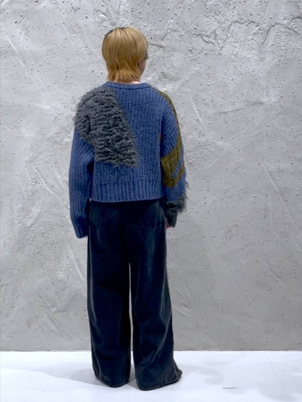 ブラック系のブーツ、ブルー系のニット/セーター、イエロー系のショルダーバッグを着用したレディースの秋コーディネートの3枚目の写真