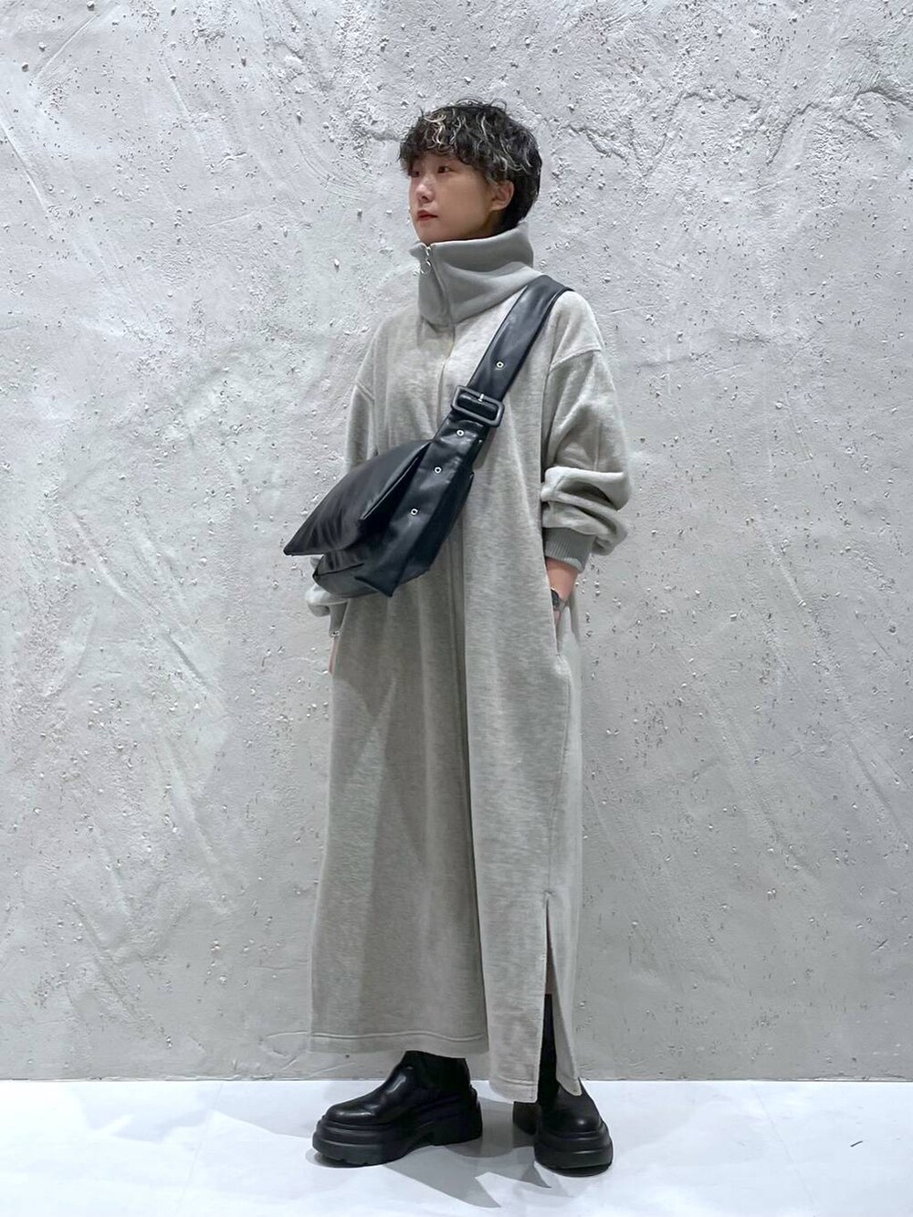 ブラック系のブーツ、グレー系のワンピース、ブラック系のショルダーバッグを着用したレディースの秋コーディネートの4枚目の写真