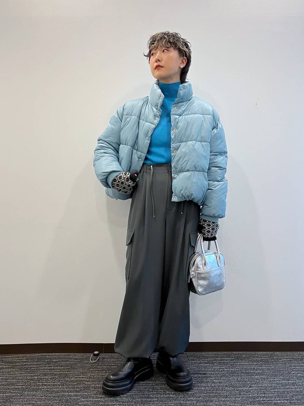 ブルー系のニット/セーター、ブルー系のブルゾン、ブラック系のブーツを着用したレディースの冬コーディネートの5枚目の写真