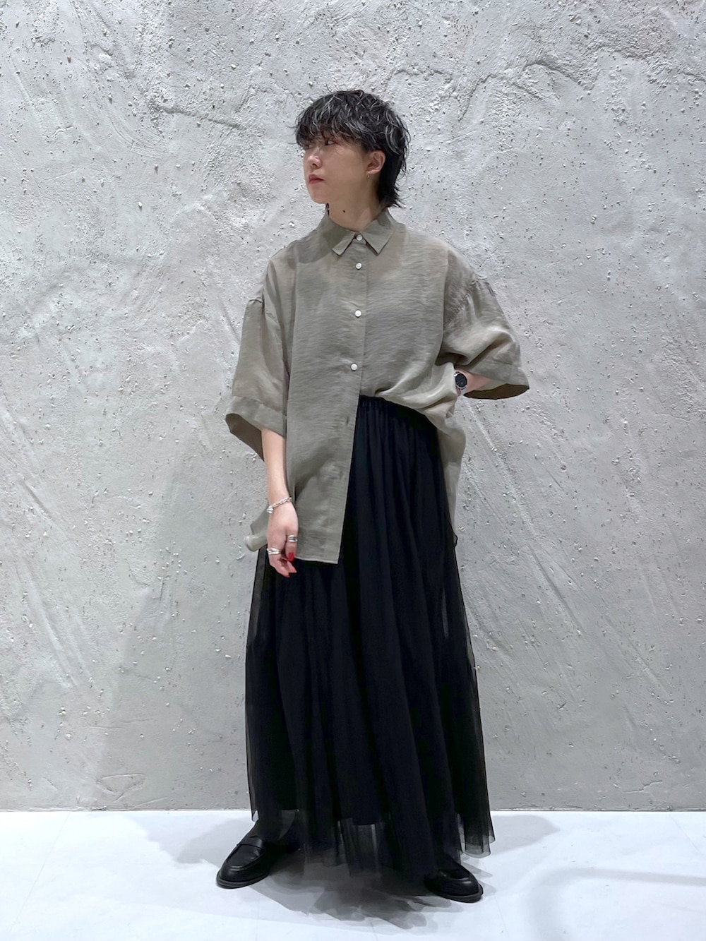 グリーン系のシャツ/ブラウス、ブラック系のスカートを着用したレディースの春コーディネートの3枚目の写真