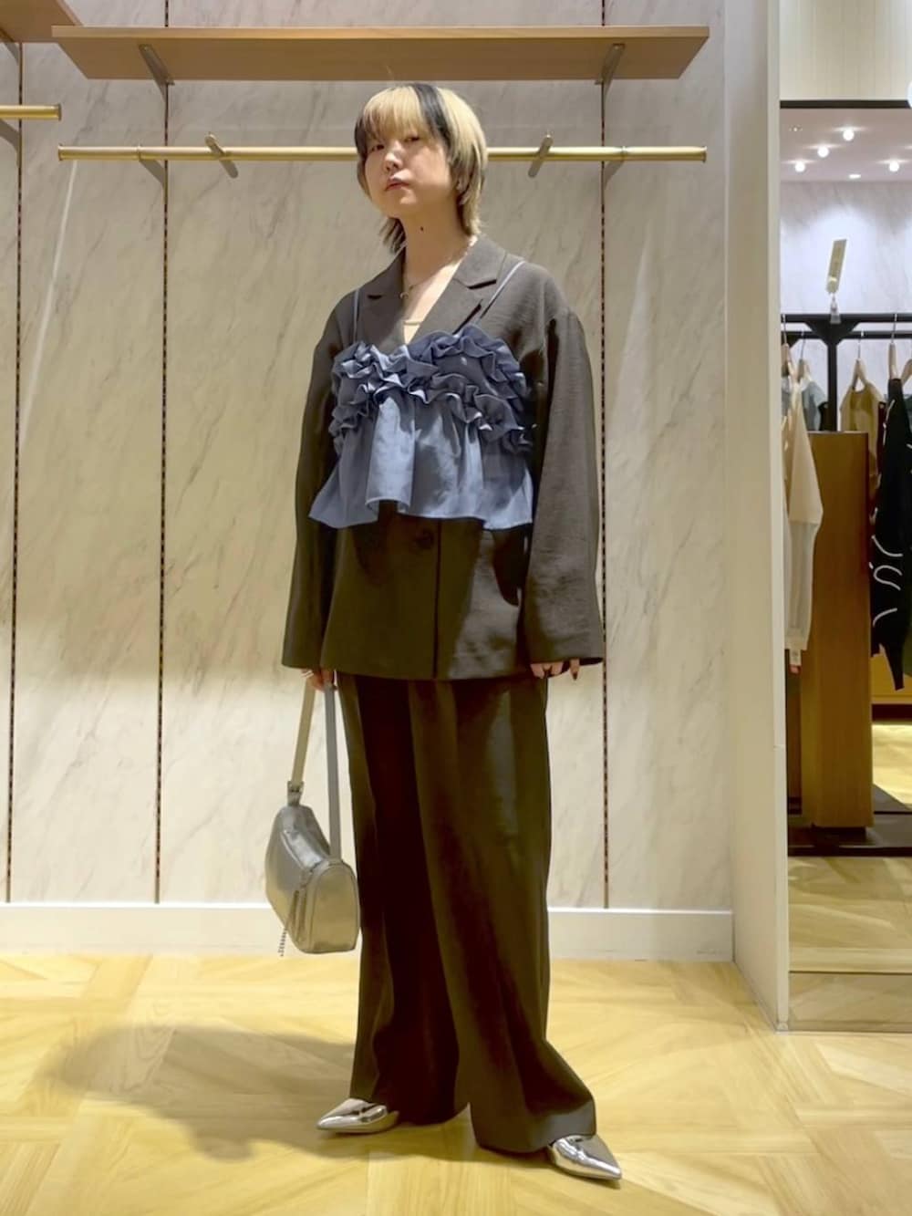 グレー系のスラックス、グレー系のテーラードジャケット、シルバー系のトートバッグを着用したレディースの春コーディネートの5枚目の写真