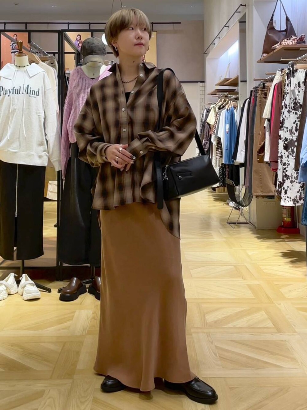 ブラウン系のシャツ/ブラウス、ブラック系のショルダーバッグ、ブラウン系のスカートを着用したレディースの秋コーディネートの3枚目の写真