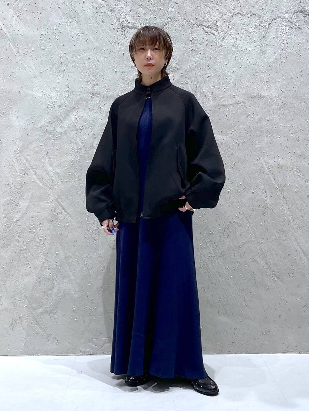 ブラック系のブルゾン、ブルー系のワンピース、ブラック系のローファーを着用したレディースの秋コーディネートの5枚目の写真