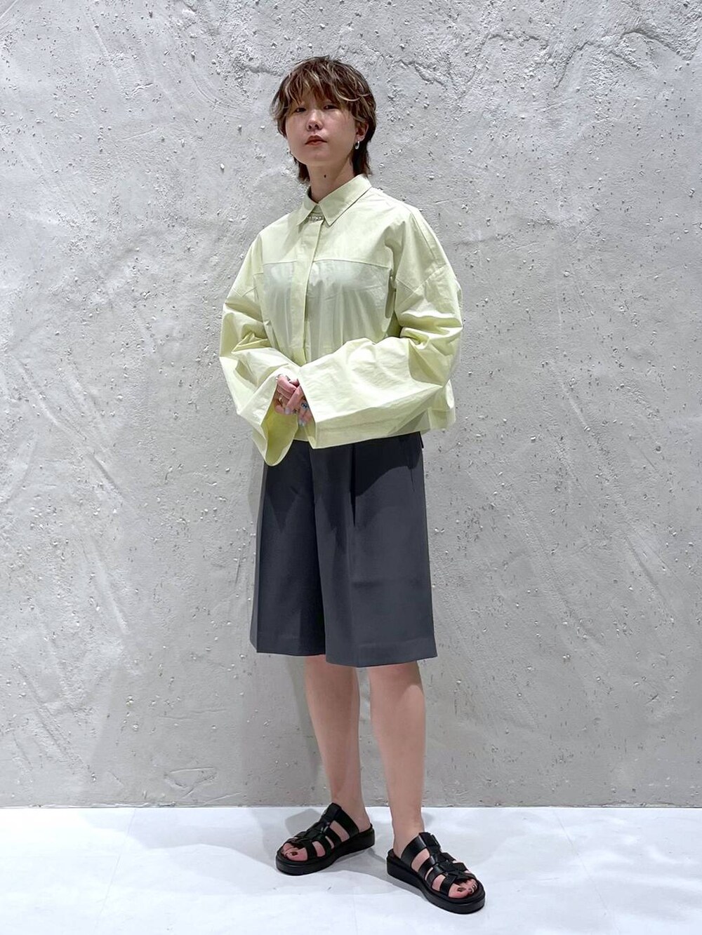 ブラック系のスニーカー、グレー系のその他パンツ、イエロー系のシャツ/ブラウスを着用したレディースの夏コーディネートの5枚目の写真