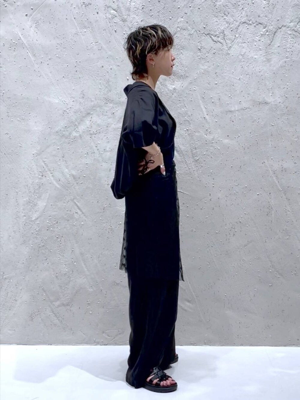 ブラック系のTシャツ/カットソー、ブラック系のスニーカー、グレー系のスラックスを着用したレディースの夏コーディネートの4枚目の写真