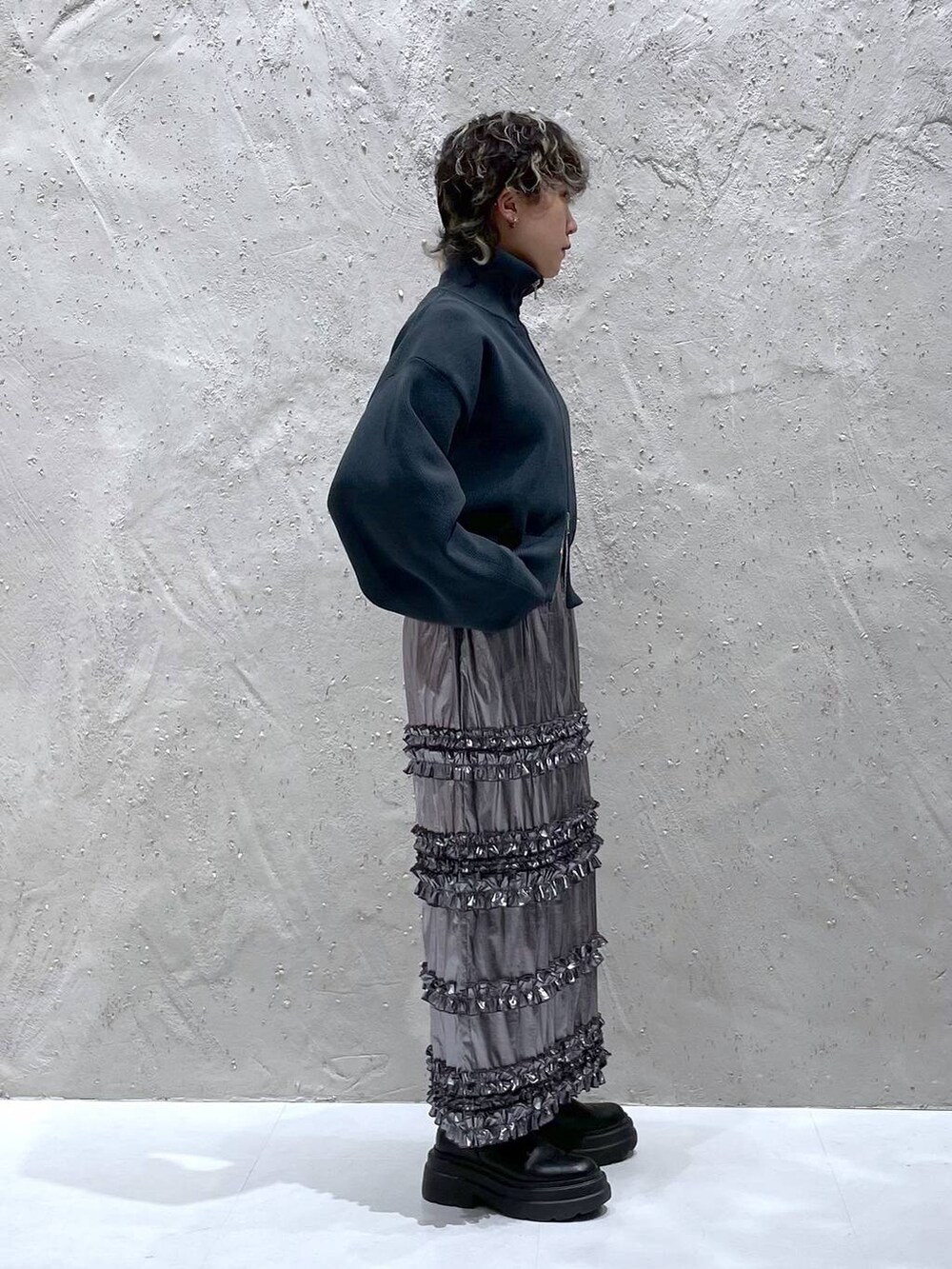 グリーン系のテーラードジャケット、シルバー系のスカート、グレー系のニット/セーターを着用したレディースの春コーディネートの7枚目の写真