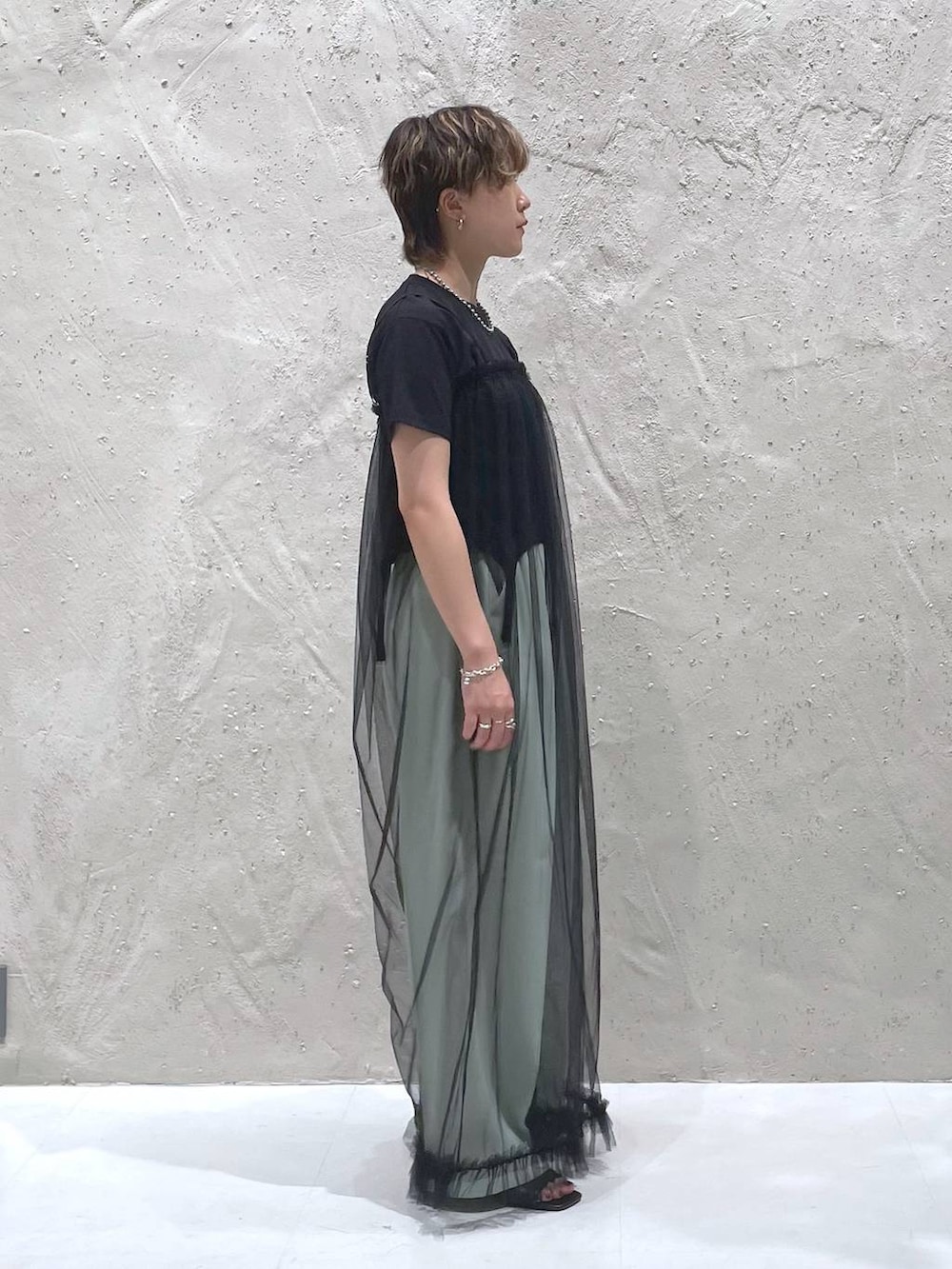 グリーン系のスラックス、ブラック系のTシャツ/カットソー、ブラック系のサロペット/オーバーオールを着用したレディースの夏コーディネートの4枚目の写真