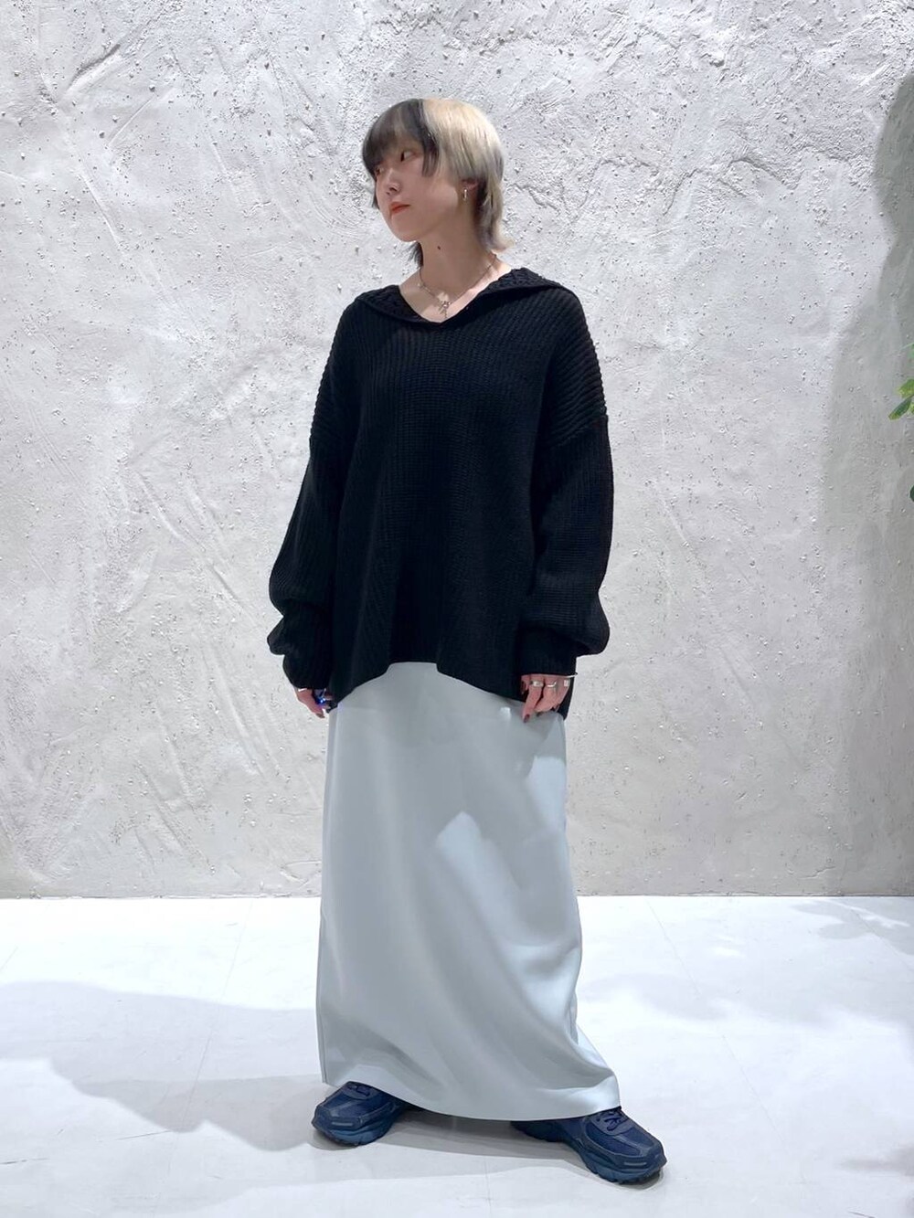 ブルー系のスカート、ブラック系のニット/セーターを着用したレディースの秋コーディネートの5枚目の写真