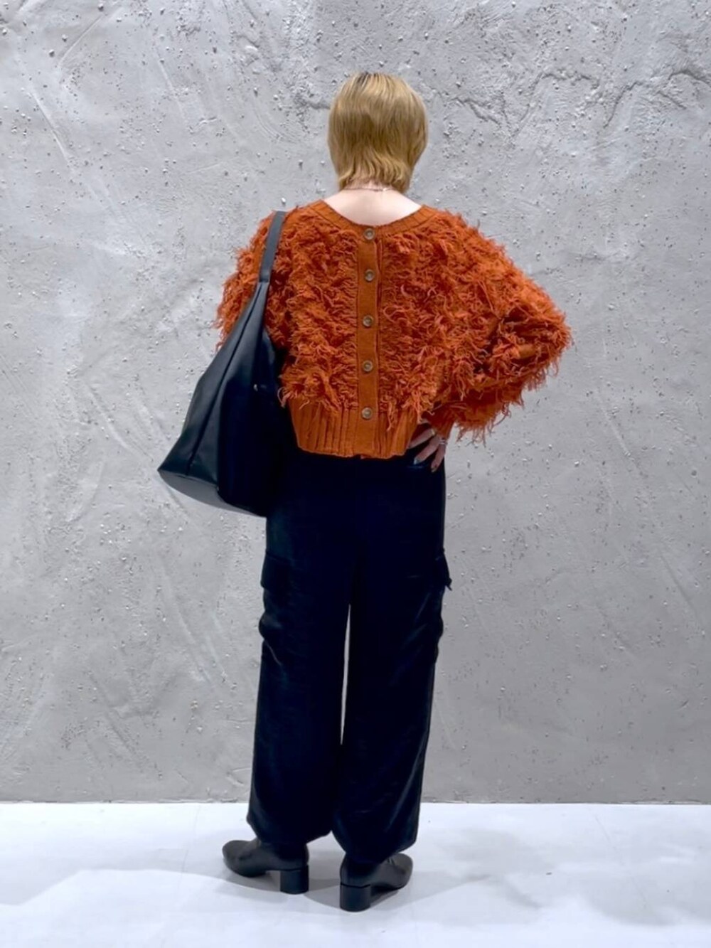 ブラック系のショルダーバッグ、ブラック系のブーツ、ブラック系のカーゴパンツを着用したレディースの秋コーディネートの3枚目の写真