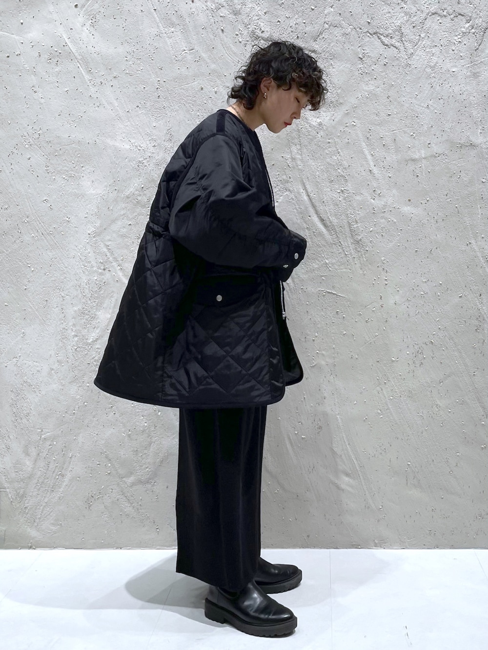 ブラック系のミリタリージャケット、ブラック系のワンピース、ブラック系のブーツを着用したレディースの冬コーディネートの2枚目の写真