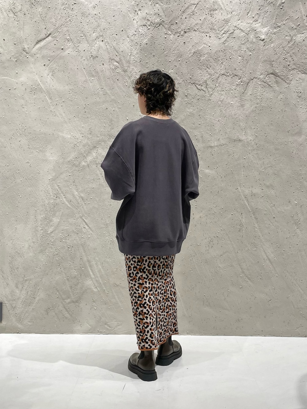 グレー系のスウェット、その他のスカート、ブラウン系のブーツを着用したレディースの秋コーディネートの2枚目の写真