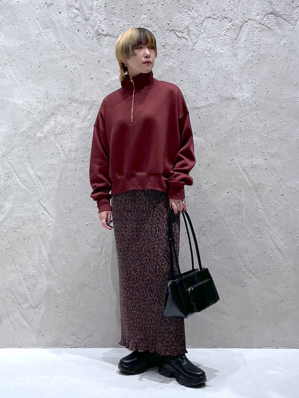 ブラック系のブーツ、ブラック系のショルダーバッグ、その他のスカートを着用したレディースの秋コーディネートの5枚目の写真