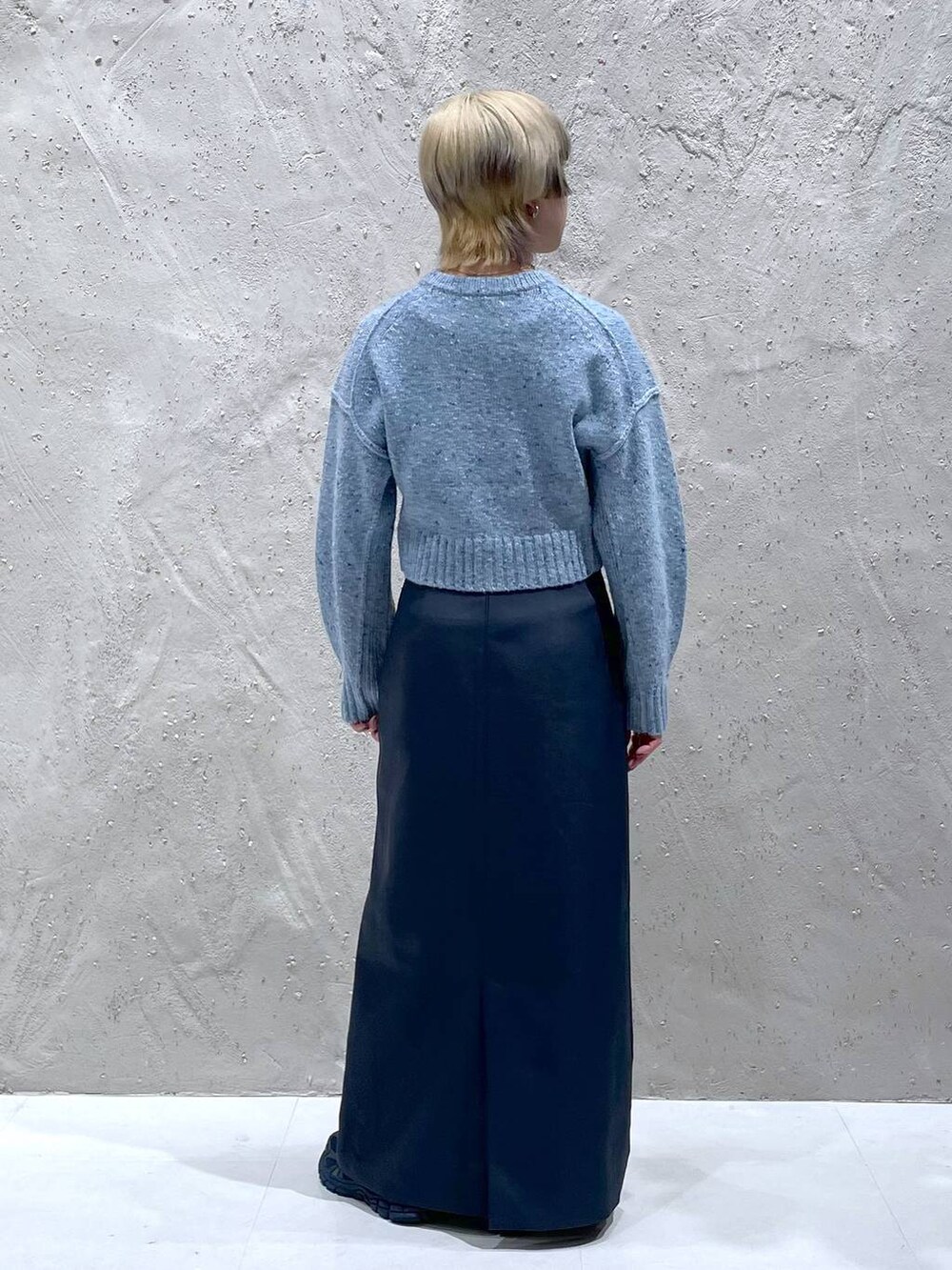 ブルー系のニット/セーター、グリーン系のスカートを着用したレディースの冬コーディネートの3枚目の写真