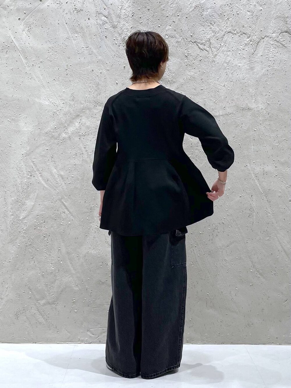 ブラック系のデニムパンツ、ブラック系のカーディガン/ボレロ、シルバー系のブーツを着用したレディースの秋コーディネートの3枚目の写真