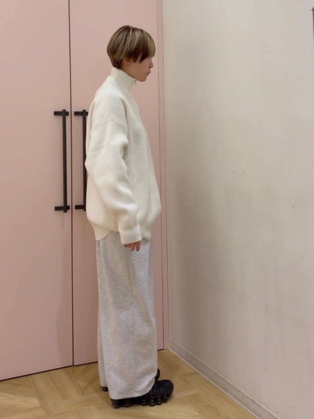 グレー系のスウェットパンツ、ホワイト系のニット/セーターを着用したレディースの冬コーディネートの3枚目の写真