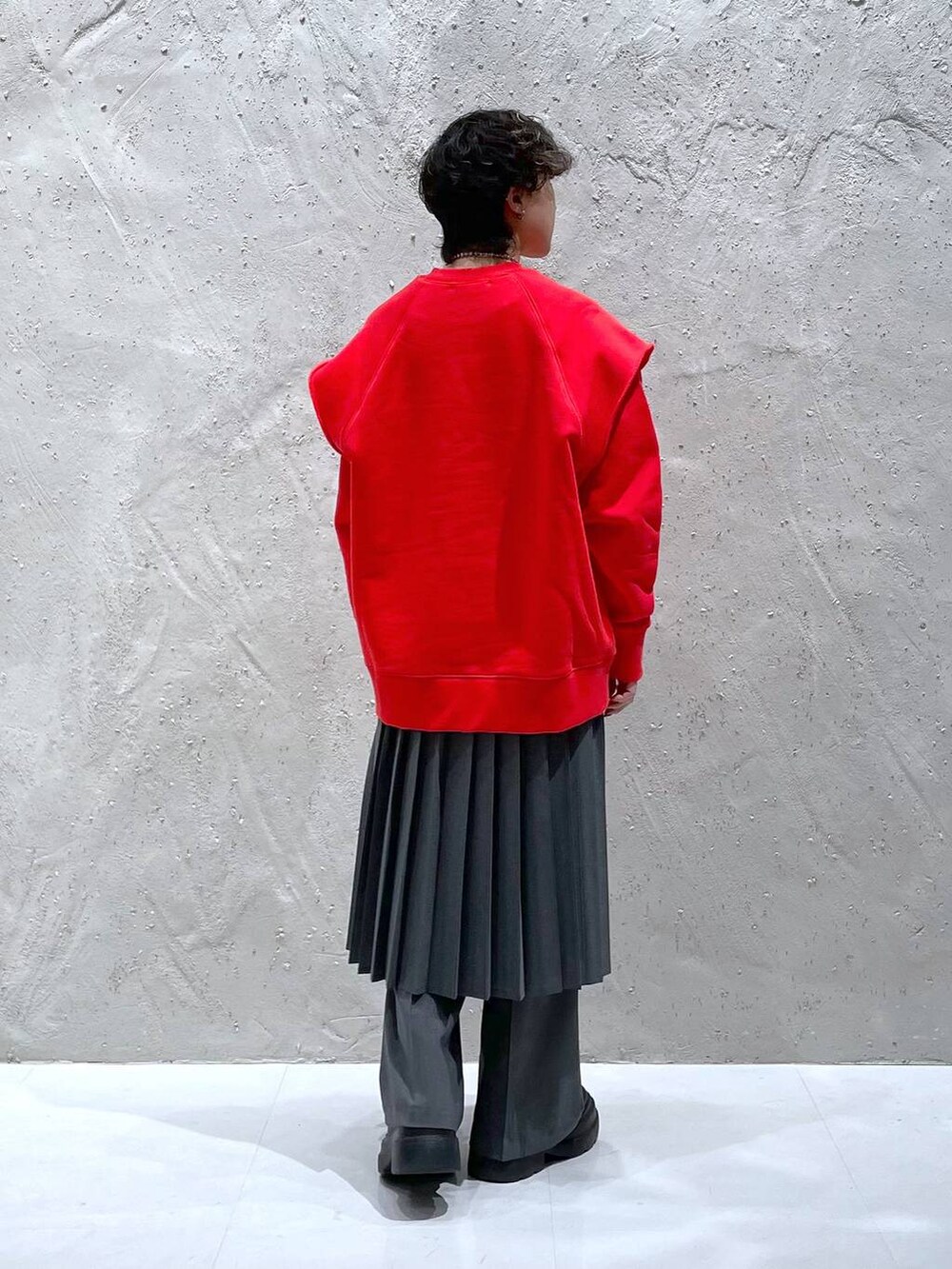 グレー系のその他パンツ、ブラック系のブーツ、レッド系のスウェットを着用したレディースの冬コーディネートの3枚目の写真