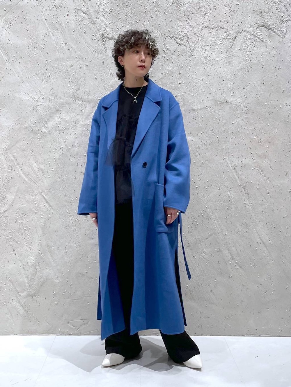 ブルー系のチェスターコート、ホワイト系のブーツ、ブラック系のその他パンツを着用したレディースの冬コーディネートの5枚目の写真