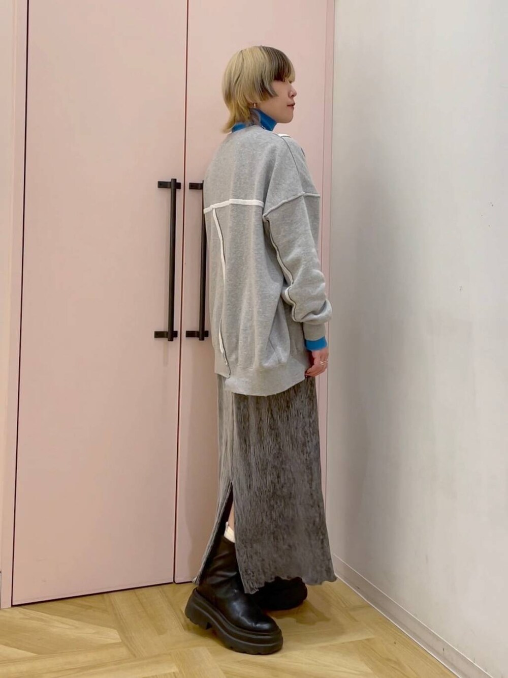 ブルー系のニット/セーター、グレー系のスカート、グレー系のスウェットを着用したレディースの冬コーディネートの3枚目の写真