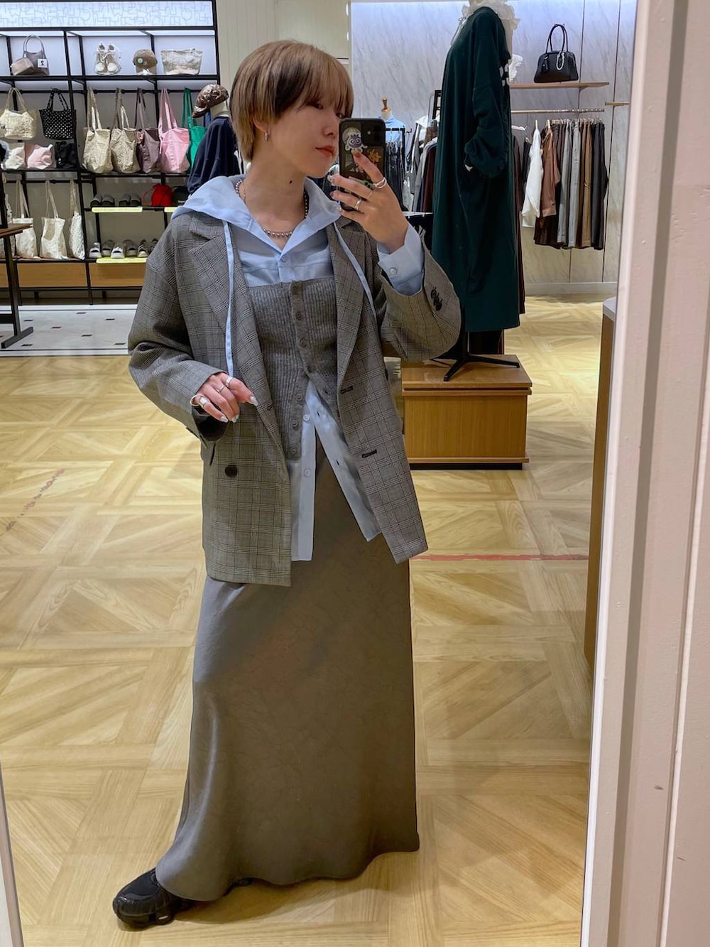 グレー系のスカート、グレー系のテーラードジャケット、グレー系のチューブトップを着用したレディースの秋コーディネートの4枚目の写真