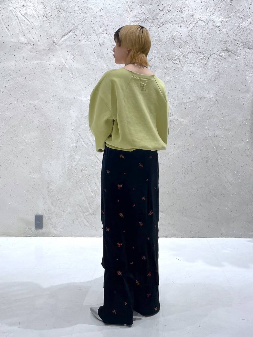 イエロー系のスウェット、シルバー系のショルダーバッグ、シルバー系のブーツを着用したレディースの秋コーディネートの3枚目の写真