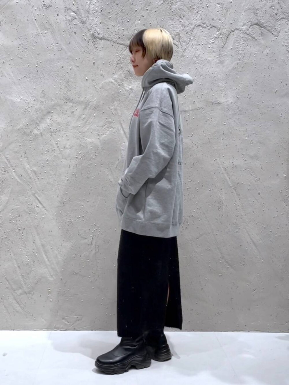 ブラック系のブーツ、ブラック系のスカート、グレー系のスウェットを着用したレディースの冬コーディネートの4枚目の写真