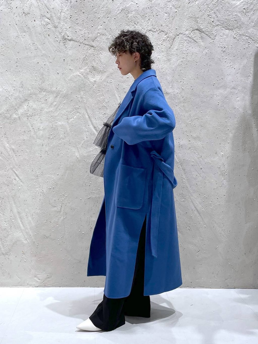 ブルー系のチェスターコート、ホワイト系のブーツ、ブラック系のその他パンツを着用したレディースの冬コーディネートの4枚目の写真