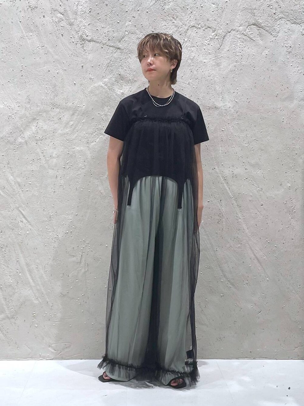 グリーン系のスラックス、ブラック系のTシャツ/カットソー、ブラック系のサロペット/オーバーオールを着用したレディースの夏コーディネートの5枚目の写真