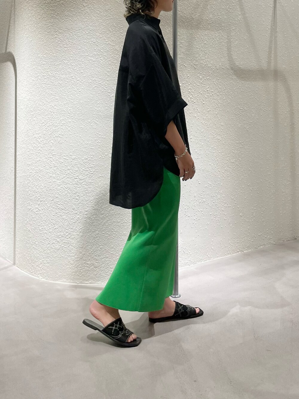 ブラック系のシャツ/ブラウス、グリーン系のスカートを着用したレディースの夏コーディネートの2枚目の写真