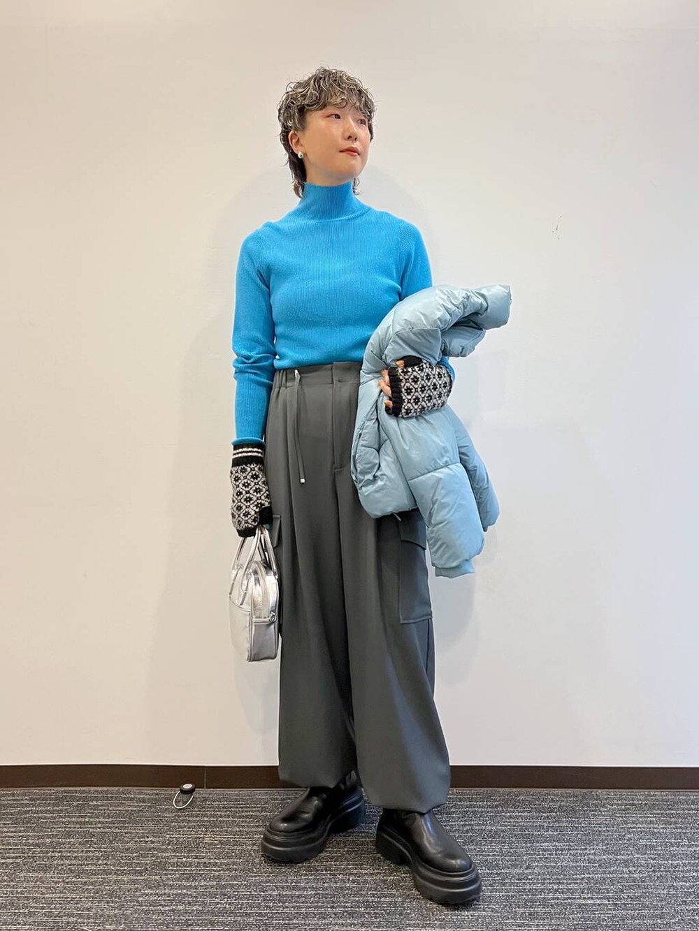 ブルー系のニット/セーター、ブルー系のブルゾン、ブラック系のブーツを着用したレディースの冬コーディネートの6枚目の写真